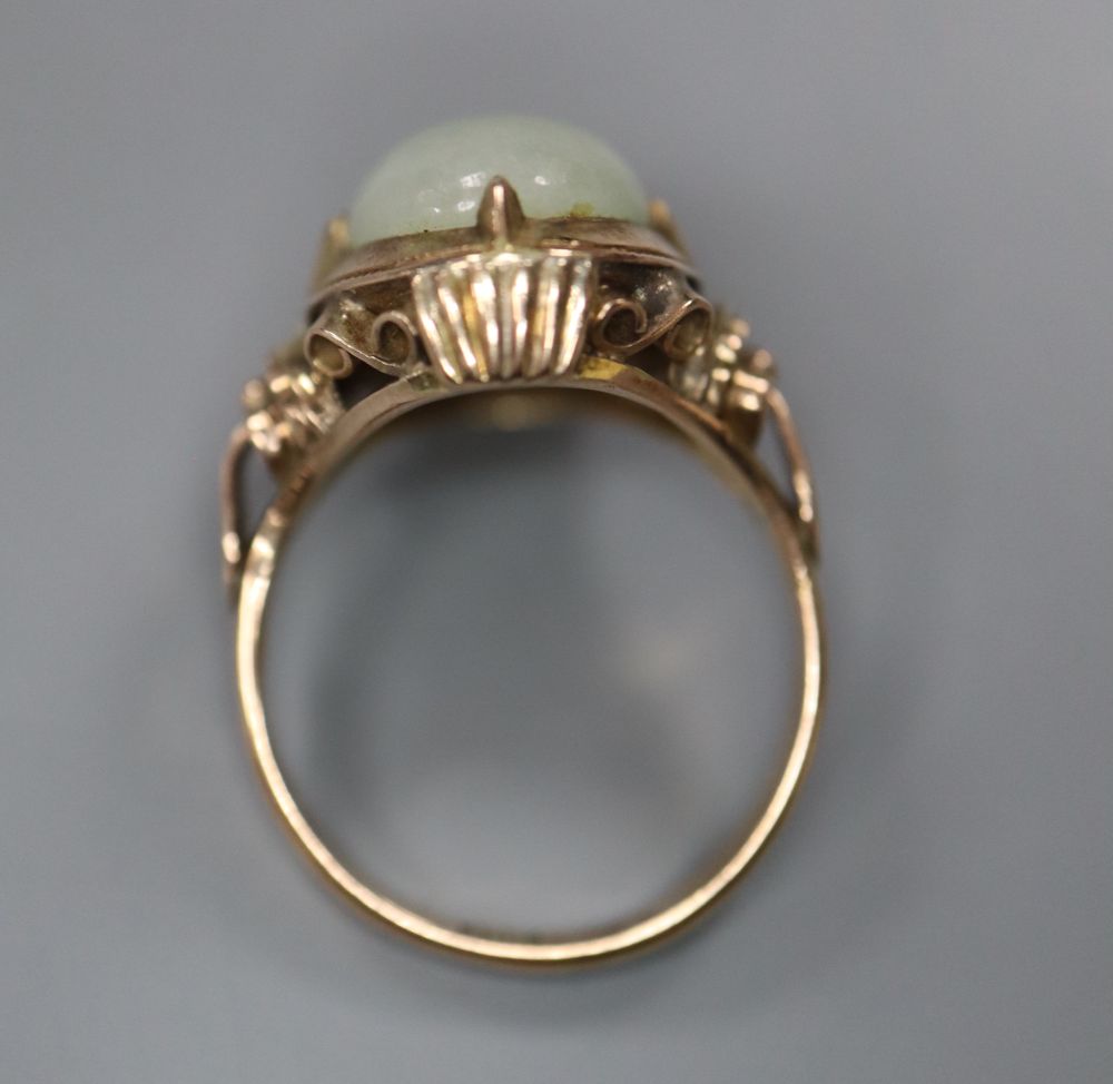 A 14k yellow metal and oval cabochon jade set ring, size L/M, gross 5 grams.